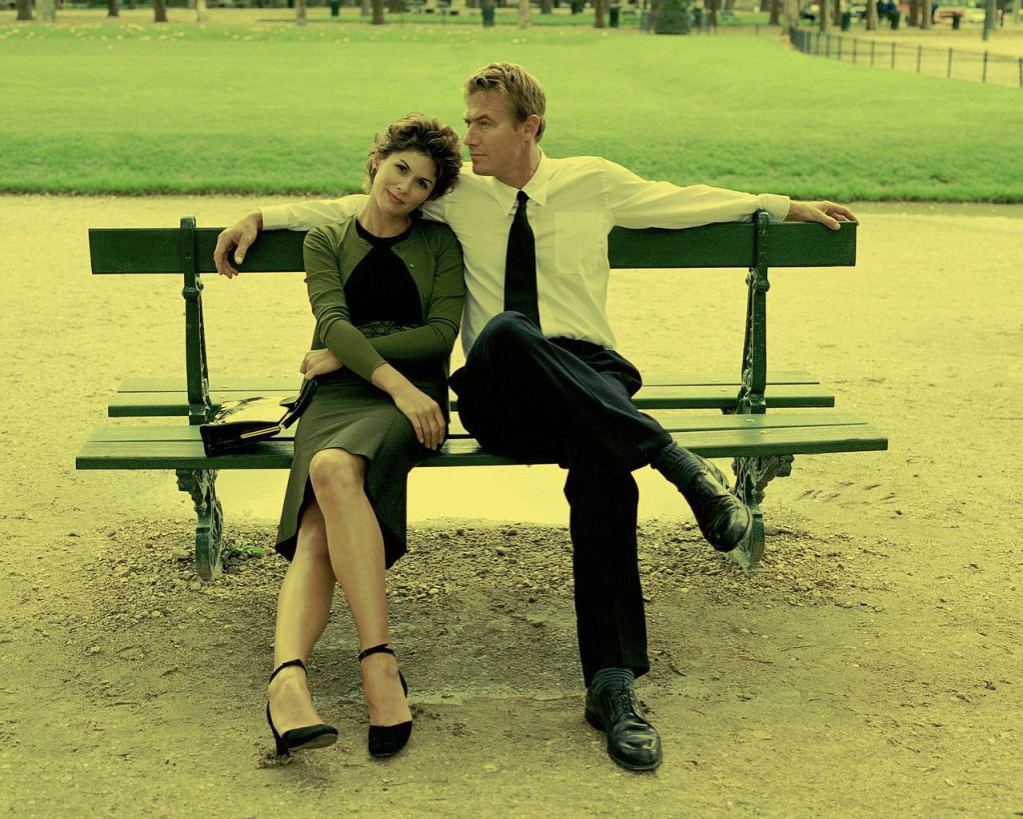 Happy couple sitting together on a park bench, representing connection and relationship healing